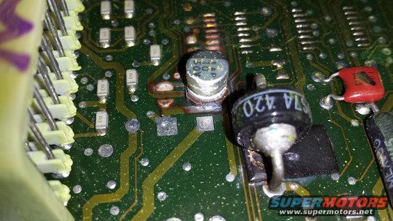 Close-up of a burned ECU circuit board with visible components and solder