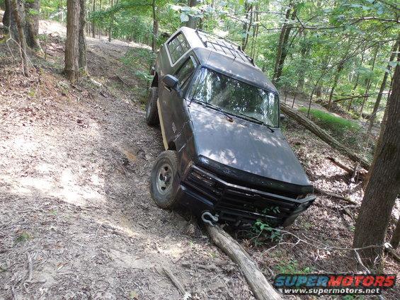 newstuck1.jpg I was just screwing around in 2WD and ran down into this ditch and got hung on this log.  After locking the hubs & working the wheels, I blew a hub lock.  Eventually, I winched out forward, drove around and came out a different trail.