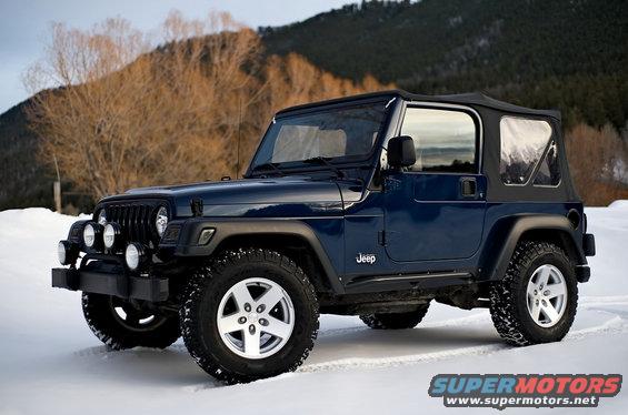Dark blue 2000 Jeep Wrangler in snow with aftermarket lights