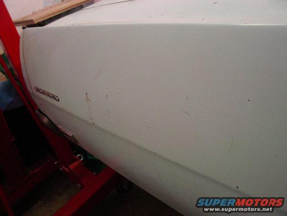 White 1969 Ford Torino door with a Torino badge, showing scratches and dents