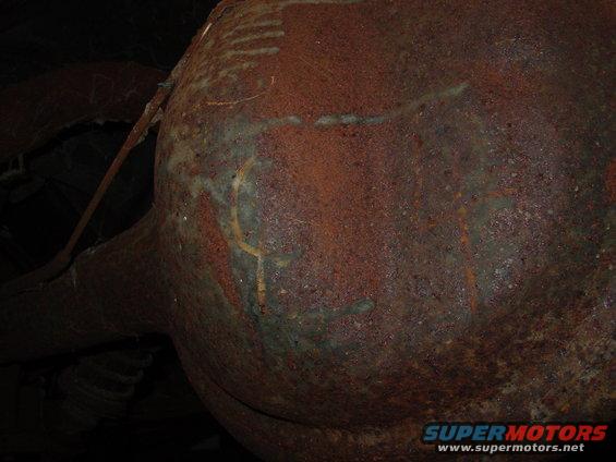 Rusted exhaust pipe and muffler with green patina