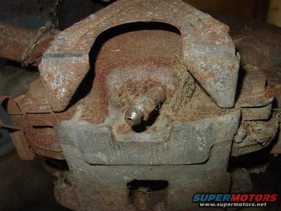 close-up of heavily rusted automotive brake caliper and suspension components