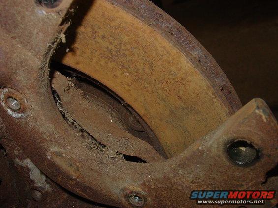 Close-up of a rusty brake drum and shoe assembly, showing wear and debris