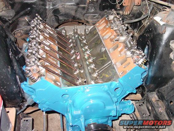Engine block with pushrods and rocker arms visible, painted bright blue