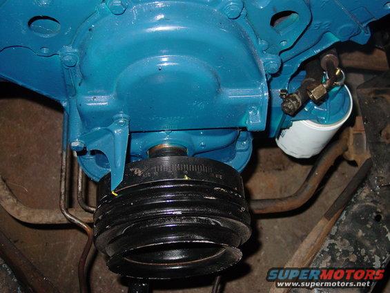 Blue painted engine block with a black pulley and oil filter attached
