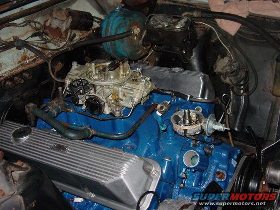 Engine bay with blue engine block, carburetor, and aluminum valve covers