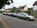 1999 Ford Fairlane - A silver sedan is parked on the side of a street lined with houses, with other vehicles visible in the background.