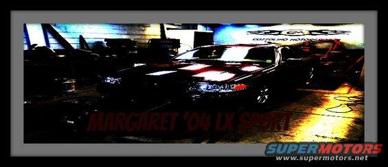 Dark 2004 Ford Crown Victoria LX Sport sedan, front 3/4 view, in a dimly lit garage