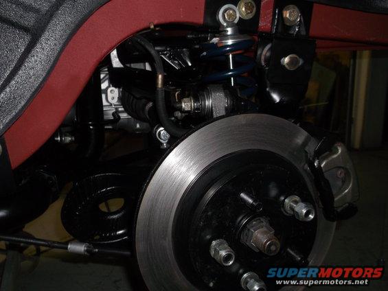 close-up of a car's rear suspension and disc brake assembly