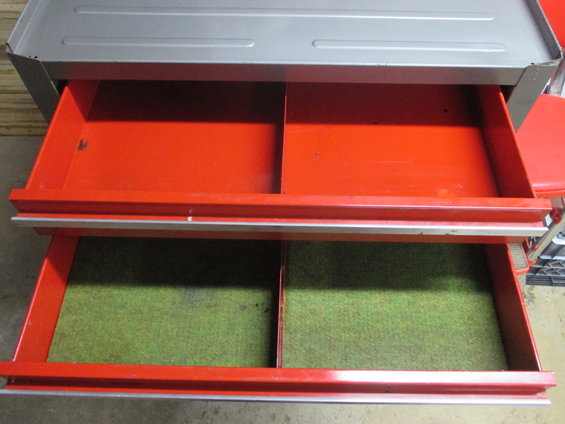 Red and gray metal toolbox with two open drawers lined with green felt