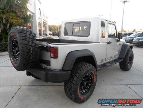 Silver Jeep JK-8 Extreme pickup conversion with spare tire mounted on the back