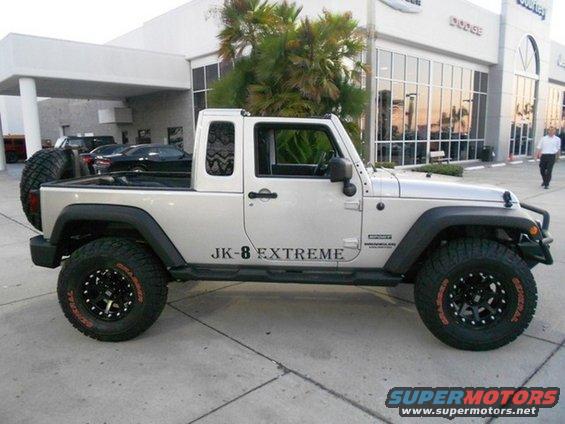 Silver Jeep Wrangler JK-8 Extreme pickup truck with spare tire on back, black fender flares, and custom wheels