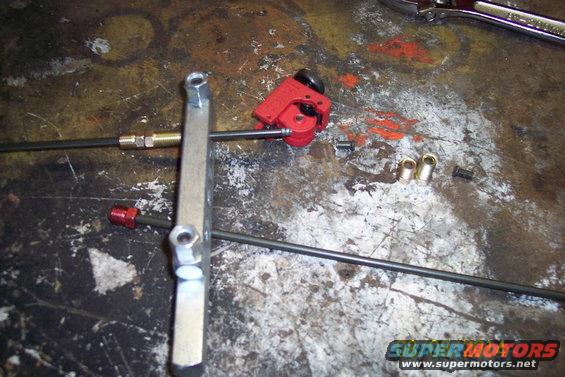 Tubing cutter, brake lines, and fittings on a workbench
