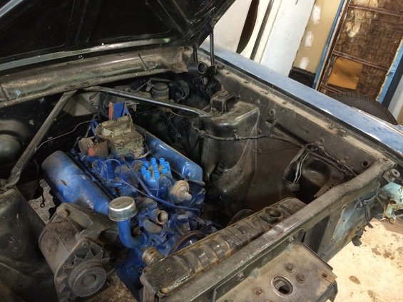 Blue engine in a 1964 Ford Fairlane engine bay, viewed from above