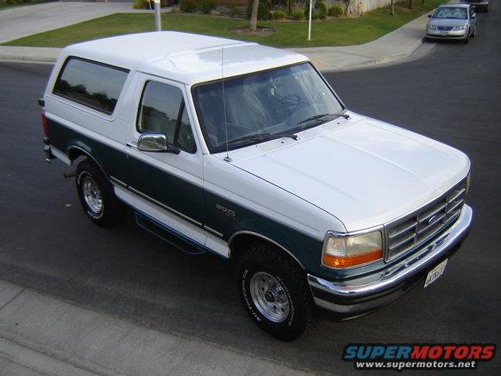 White and green Ford Bronco parked on a street