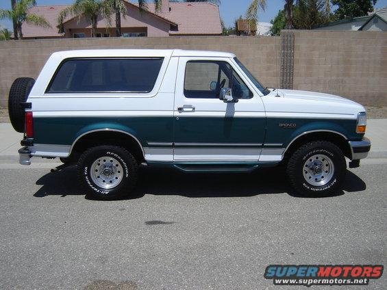 Two-tone green and white Ford Bronco with a spare tire on the back