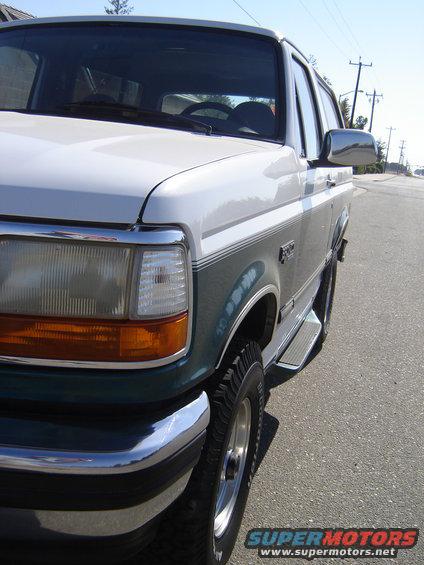 Front quarter view of a white and green 1996 Ford Bronco parked on a street