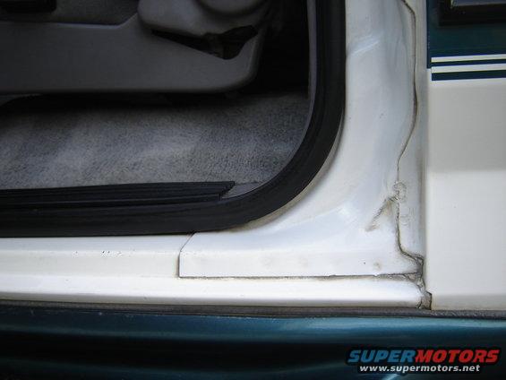 Close-up of a car's interior door frame and carpeted floor