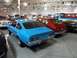 1971 Ford Ranchero - Multiple vehicles displayed indoors, including a blue coupe and a red hatchback.