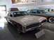 1971 Ford Ranchero - A white station wagon with wood paneling and a roof rack is displayed in a museum next to a blue station wagon.