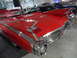 1971 Ford Ranchero - A classic red convertible with distinctive tail fins is displayed indoors, with other vehicles visible in the background.