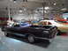 1971 Ford Ranchero - A dark purple 1968 Ford Ranchero is displayed indoors alongside other vehicles.