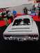 1971 Ford Ranchero - A customized car with a prominent engine is displayed at an indoor event.