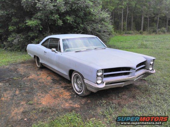 Light blue 1966 Pontiac Catalina coupe, primer finish, parked on dirt and grass