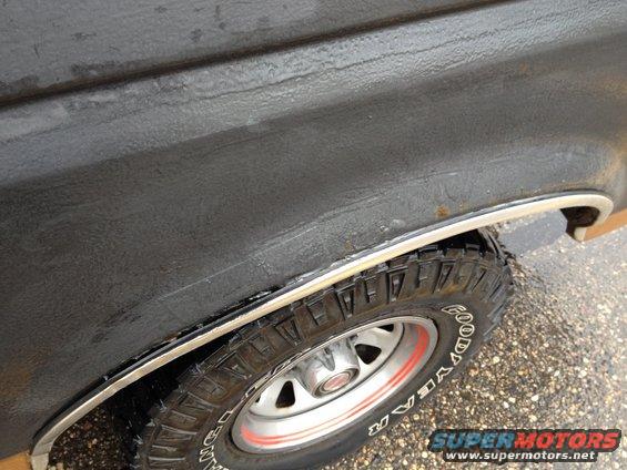 Close-up of a vehicle's rear wheel well with a Goodyear tire and a chrome trim piece