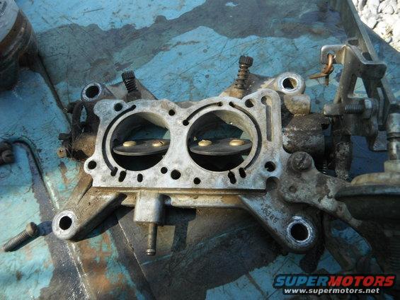 Close-up of a carburetor with two barrels and visible linkage