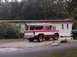 1979 Ford Bronco II - This red and white Ford Bronco is parked next to a mobile home, with a dark SUV visible on the right.