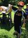 1979 Ford Bronco - A young boy in a Pirates shirt and camouflage hat holds a shock absorber while standing in a yard with a table of parts nearby.