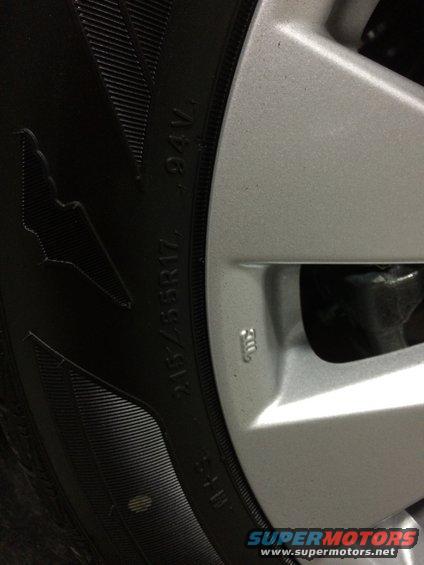 Close-up of a silver alloy wheel and tire with size 215/55R17