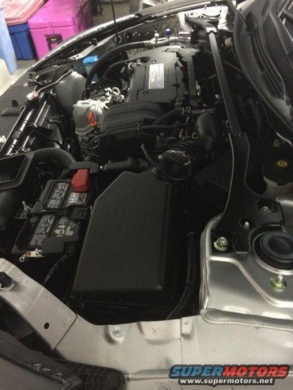 Silver Honda Accord engine bay with black engine cover and battery