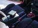 1993 Mazda MX-3 - Interior view of a car's center console and seats, a manual transmission shifter with a red leather boot.