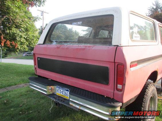 Red and white SUV rear view, showing chrome bumper, license plate HTX-4366, and a black panel on the tailgate