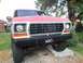 1979 Ford Bronco - The front grille and headlights of a classic Ford Bronco are visible, parked on concrete blocks.
