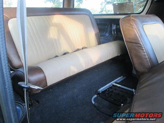 Rear bench seat and floor of a vehicle interior. A metal seat frame is on the floor