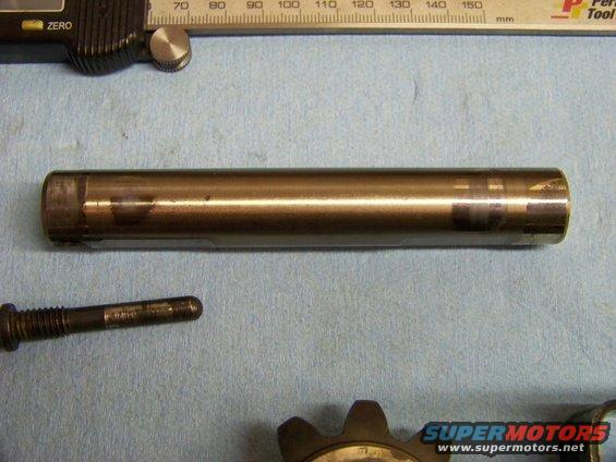 Metal cylinder and bolt on blue shop towel with ruler and caliper