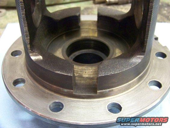 Close-up of a differential carrier housing with bolt holes around the flange
