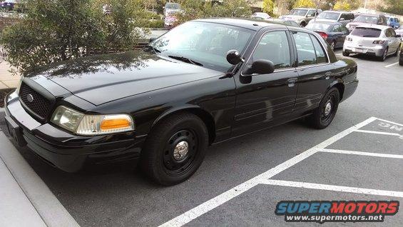 Black sedan parked in a lot. It looks like a 2005 Ford Crown Victoria