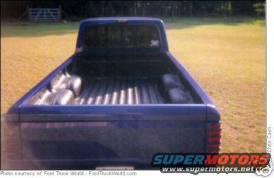 1996 Ford Ranger pickup truck bed, blue exterior, parked in a grassy field
