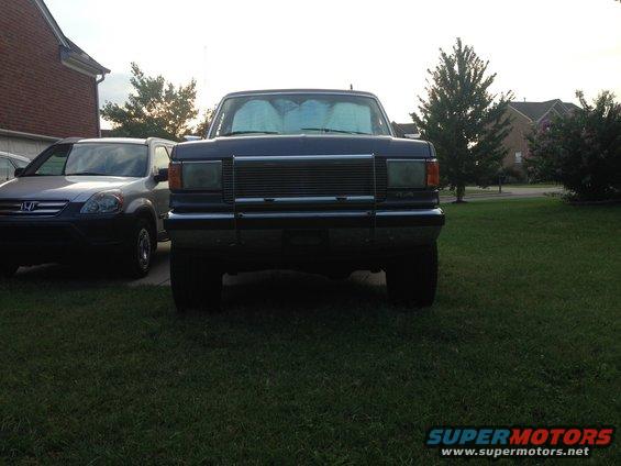 1990 Ford Bronco front view, parked next to a silver SUV