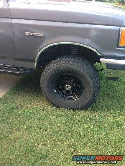 Gray 1990 Ford Bronco fender and wheel with black rim