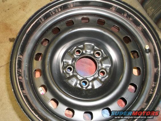Steel wheel rim with multiple lug nut holes and a valve stem