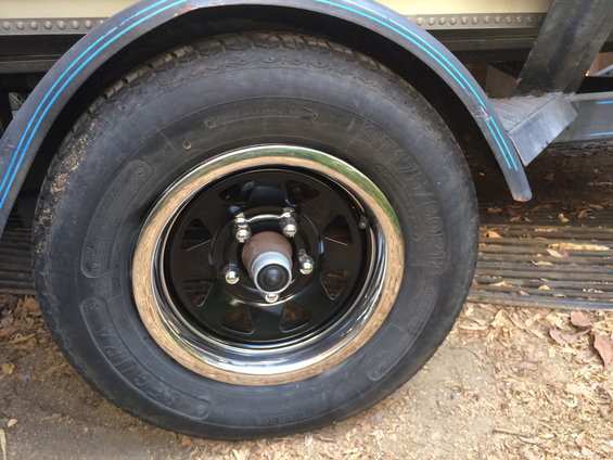 Trailer wheel with black rim and chrome lip, tire shows ST175/80R13 markings