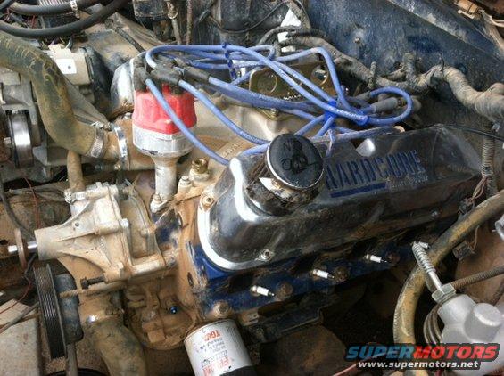 Engine with chrome valve covers reading "HARDCORE", blue spark plug wires, and a red distributor cap