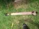1979 Ford Bronco - A driveshaft lies on the grass, showing signs of rust and wear.