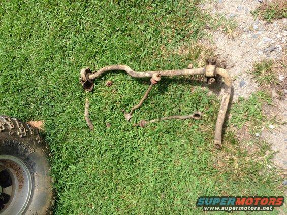 Suspension parts on grass with a tire in the corner