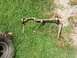 1979 Ford Bronco - Various suspension components, including a sway bar, lie on the grass next to a tire.